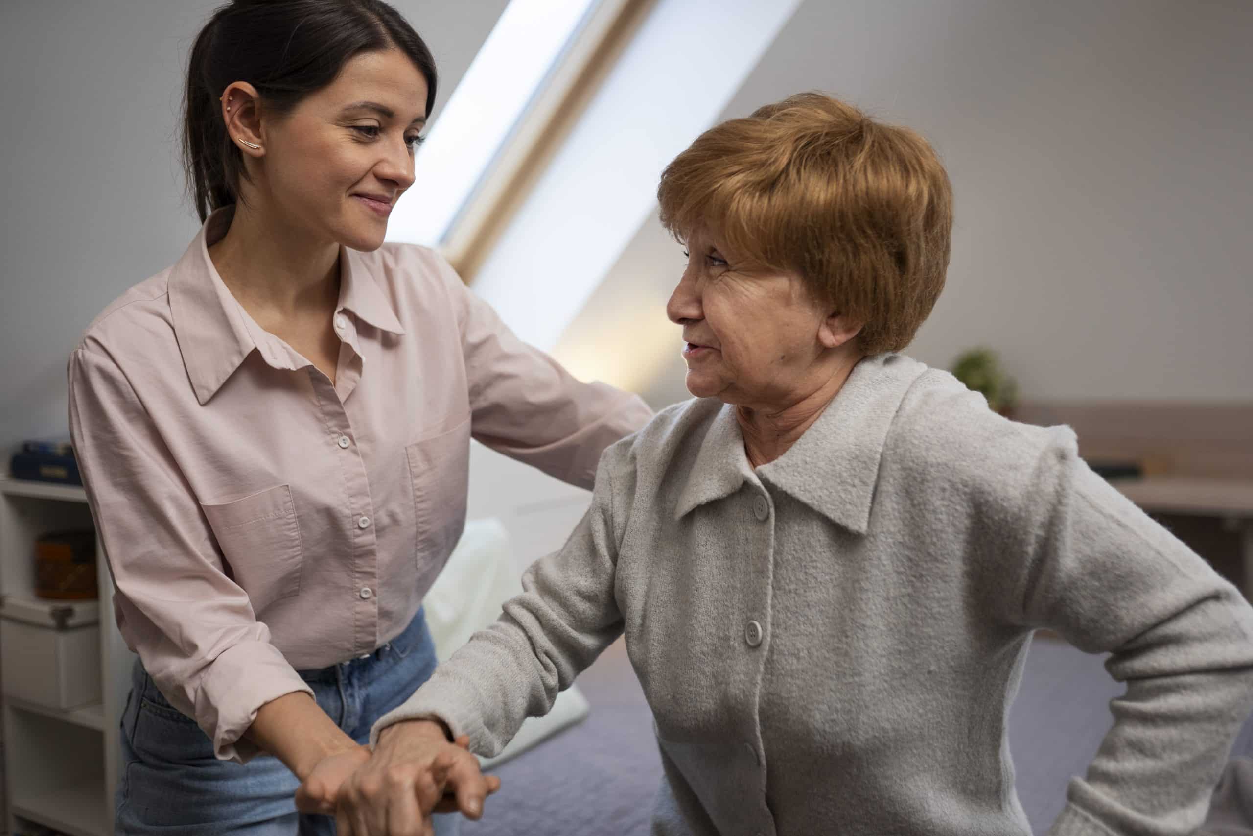 Ältere Person, die von einer weiblichen Pflegekraft betreut wird